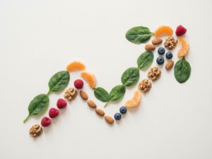 Energievoeding zoals spinazie, citrusvruchten, bessen en noten in geometrische patronen op witte achtergrond