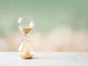 Zandloper met gouden zanddeeltjes die transformeren in hormoonmoleculen tegen zachte groene achtergrond