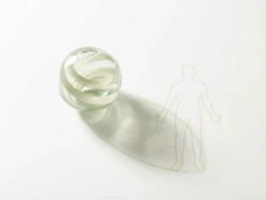 Glazen bol met vloeiende gedachtenlinten naast menselijke silhouet op witte ondergrond, zachte schaduwen in salie groen en crème tinten