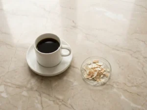 Witte keramische koffiemok naast glazen schaaltje met huidschilfers op marmeren oppervlak, overhead perspectief